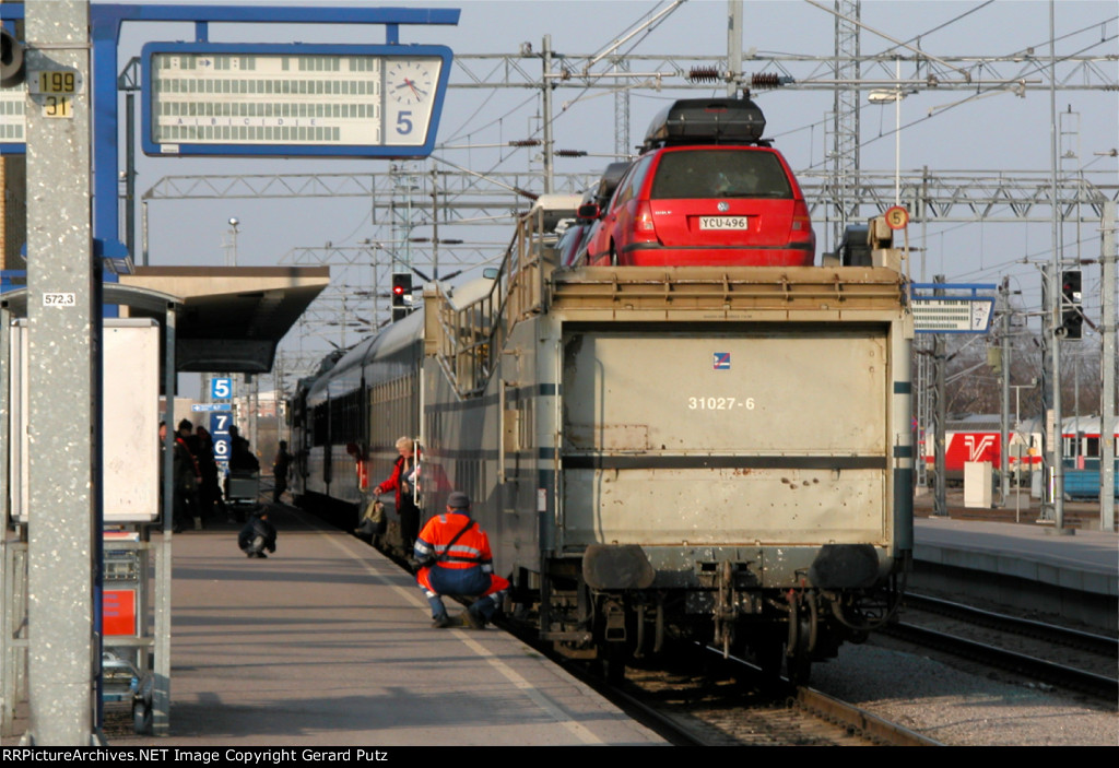 VR w/b train at station with auto carrier on rear